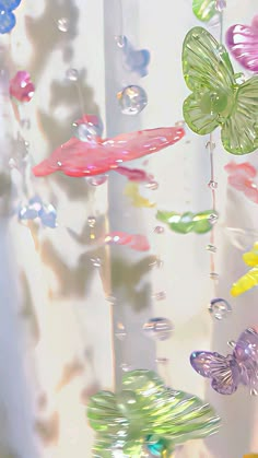 colorful glass butterflies are hanging from the ceiling