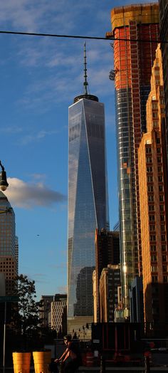 a tall building towering over a city next to other tall buildings and skyscrapers in the distance