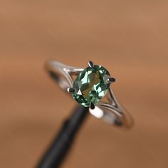 It is a green sapphire ring. The main stone is 6mm*8mm oval cut, weight about 1.75 carats. The basic metal is sterling silver and plated with rhodium. To change the metal to a solid gold (white/rose) or platinum is also available, please ask for a quotation if you want. You can also go to my shop Home for more elegant rings: https://www.etsy.com/shop/godjewelry?ref=hdr_shop_menu More rings: https://www.etsy.com/shop/godjewelry?ref=l2-shop-header-avatar Customization is always welcome and please Green Oval Diamond Ring In Sterling Silver, Green Solitaire Sterling Silver Ring, Formal Green Sapphire Sterling Silver Ring, Green Solitaire Crystal Ring In Sterling Silver, Green Sapphire Ring Sterling Silver, May Birthstone, Lauren Johnson, Green Sapphire Ring, Green Sapphire, Star Ring