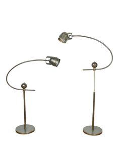 two metal lamps with one light on each pole and the other on top of it