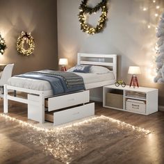 a white bed sitting on top of a wooden floor next to a night stand with lights