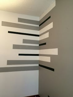 an empty room with white walls and black strips on the wall