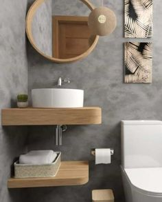 a bathroom with a toilet, sink and mirror in it's corner area on the wall