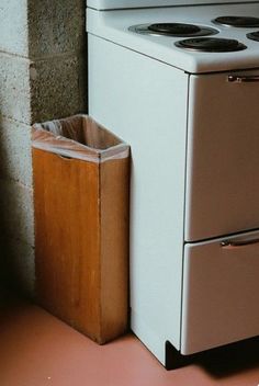 a stove top oven sitting next to a trash can