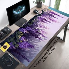 a computer desk with a purple flower design on the top and an extra large monitor behind it