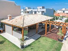 an outdoor covered patio with seating and pergolated area in the foreground, surrounded by apartment buildings