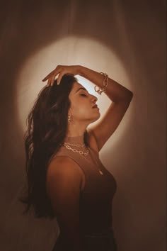 a woman is posing for a photo with her hands on her head