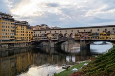 a river running through a city with tall buildings on both sides and a bridge in the middle