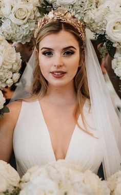 a woman in a wedding dress with flowers around her head