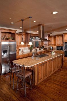 a large kitchen with wooden cabinets and an island in front of the stove top oven