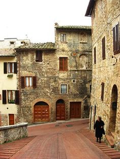 a person walking down an alley way between two buildings