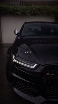 an audi car parked in front of a house with the word audi on it's grille