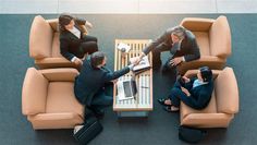 three business people sitting around a coffee table