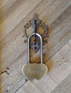 a heart shaped padlock attached to a wooden wall