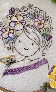 a close up of a embroidery on a piece of cloth with flowers and a butterfly