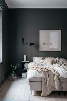 a bedroom with dark walls and white flooring