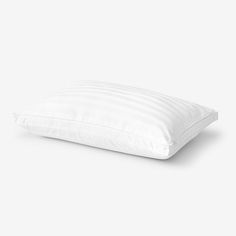 a white pillow sitting on top of a bed