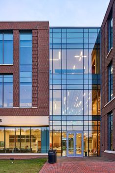 an office building with large windows and brick walkway