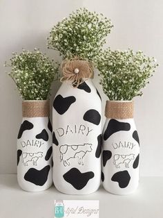 three vases decorated with cows and baby's breath flowers