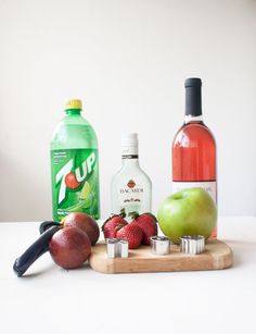 an assortment of fruit and drinks on a cutting board