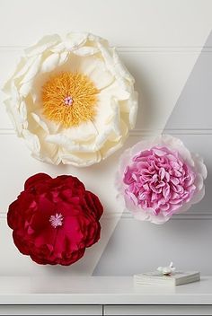 two large flowers sitting on top of a white table