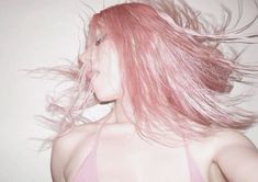 a woman with pink hair blowing in the wind