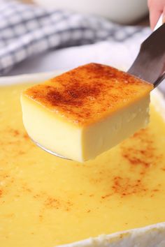 a person holding a knife over a bowl of cheese