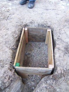 a man standing on top of a rock next to a hole filled with dirt and gravel