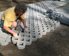 a man kneeling down to put cement on the ground