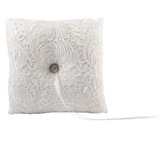 a white lace pillow with a button on the front and an attached cord to it