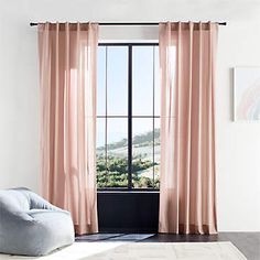 a living room with a large window and pink curtains