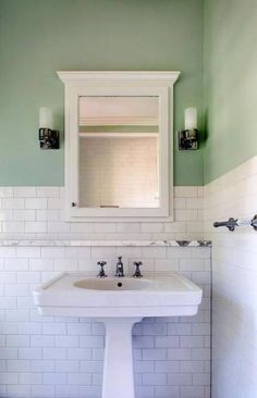 a white sink sitting under a bathroom mirror