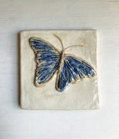 a ceramic tile with a blue butterfly on it