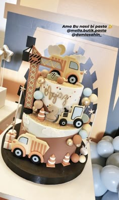 a three tiered cake decorated with trucks and balloons