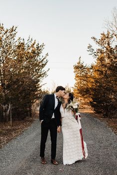 a newly married couple kissing on the road