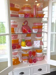 a china cabinet filled with lots of dishes and cups on top of it's shelves