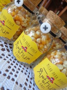 three jars filled with corn sitting on top of a table