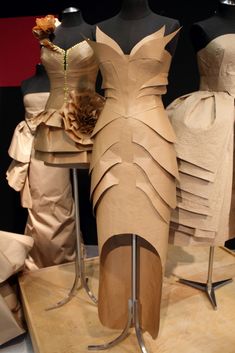 three mannequins with dresses made out of paper