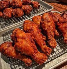 two trays filled with fried chicken on top of a table