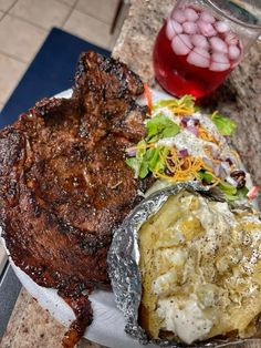 steak, potatoes and salad on a plate next to a glass of red wine