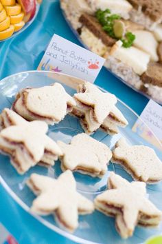 there are many small sandwiches on the plate and in front of each other, along with candy