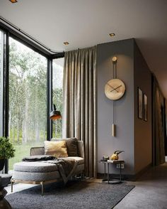 a living room with large windows and a clock mounted on the wall above the couch