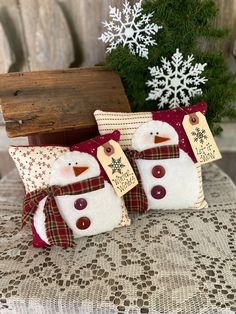 two snowman pillows sitting on top of a table