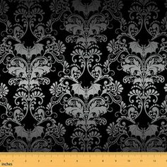 a black and white wallpaper with an ornate design on it's side, next to a ruler