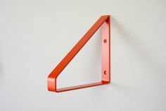 an orange shelf mounted to the side of a wall