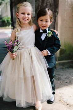 two young children dressed in formal wear posing for the camera