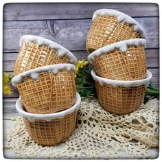 three waffle cups sitting on top of a doily with flowers in the background