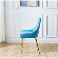 a blue chair sitting on top of a hard wood floor next to a white wall