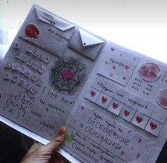 a person holding up a piece of paper with stickers on it and writing on it