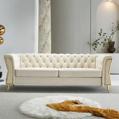 a living room with a white couch and gold accents